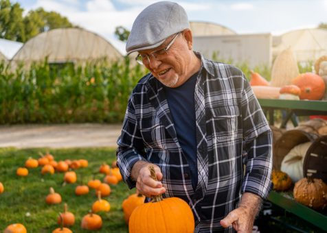 Latin man picking pumpkins during Autumn