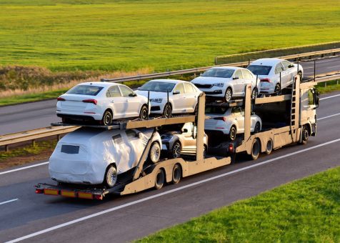 Car,Carrier,Trailer,Transports,Cars,On,Highway,On,Sunset,Background.